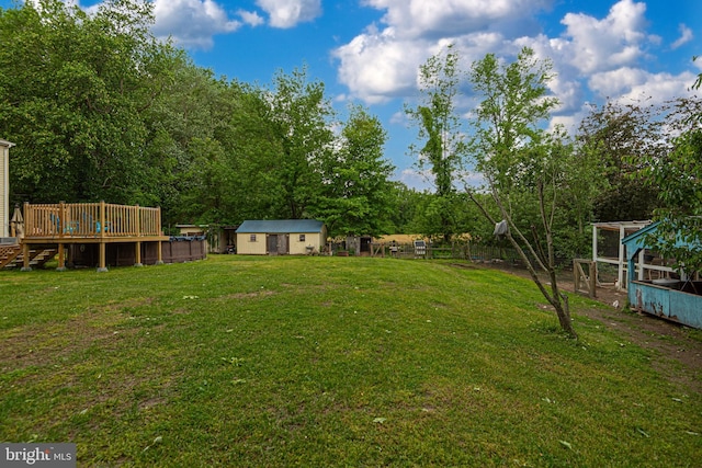 view of yard featuring a wooden deck and an outdoor structure