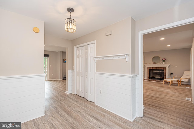 corridor with a notable chandelier and light hardwood / wood-style flooring