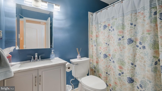 bathroom featuring toilet, a shower with curtain, and vanity