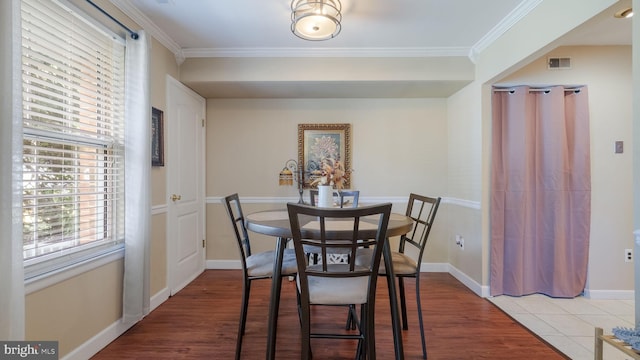 dining space featuring hardwood / wood-style flooring and crown molding