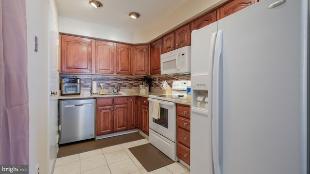 kitchen with backsplash, white appliances, and light tile patterned flooring