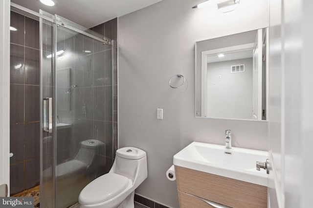 bathroom with vanity, toilet, and a shower with door