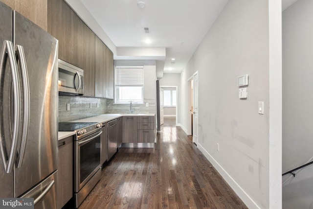 kitchen with stainless steel appliances, backsplash, dark hardwood / wood-style floors, and sink