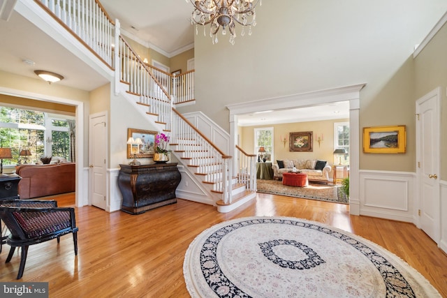 foyer with light hardwood / wood-style floors, a high ceiling, and plenty of natural light