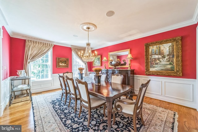 dining room featuring light hardwood / wood-style floors, crown molding, and an inviting chandelier