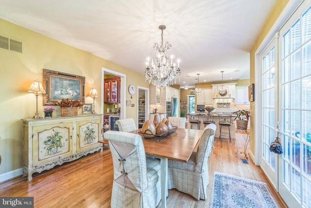 dining area featuring a notable chandelier and light hardwood / wood-style floors