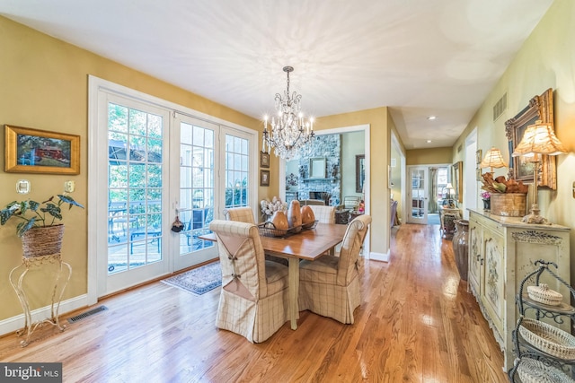 dining space featuring an inviting chandelier and light wood-type flooring