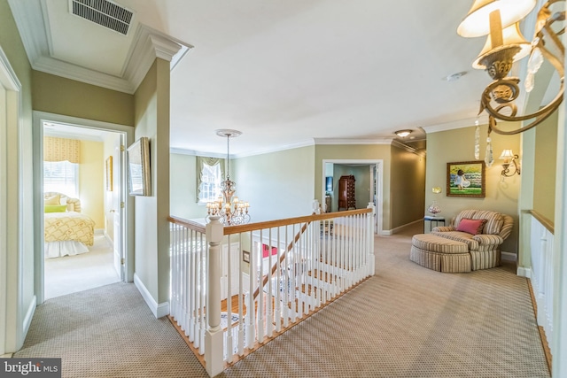 hallway with a notable chandelier, ornamental molding, and light colored carpet