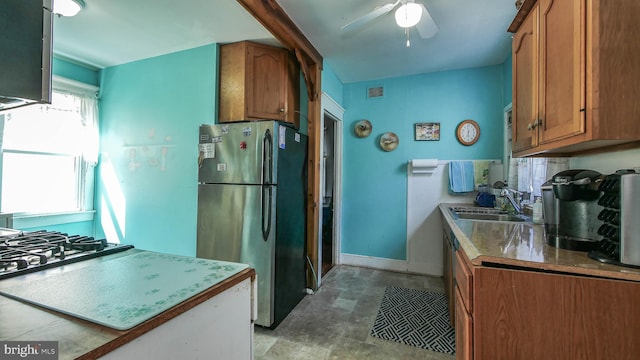 kitchen with gas cooktop, ceiling fan, sink, and stainless steel fridge