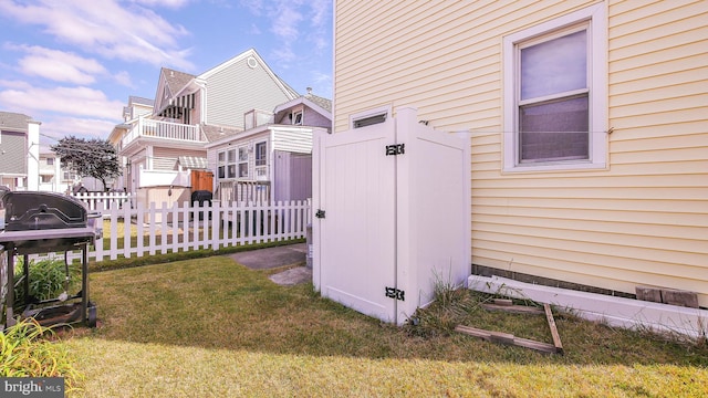 view of side of home featuring a balcony, a lawn, and a shed