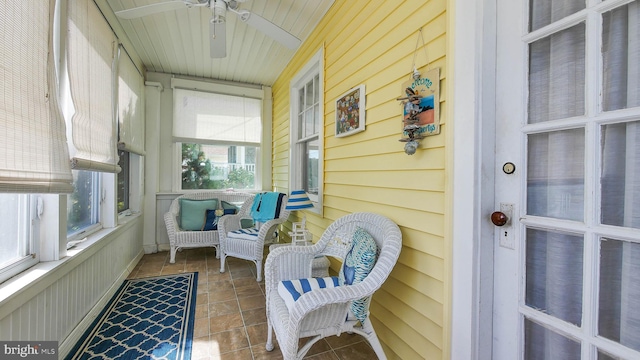 sunroom featuring a healthy amount of sunlight, wood ceiling, and ceiling fan