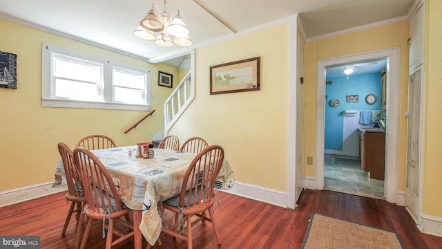 dining space with ornamental molding, a chandelier, and dark hardwood / wood-style floors