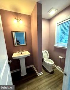 bathroom featuring hardwood / wood-style floors and toilet