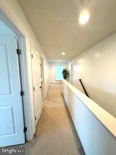 hallway featuring light colored carpet