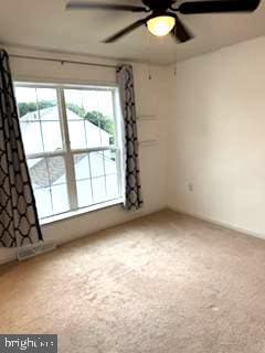 spare room featuring ceiling fan and carpet flooring