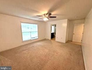 empty room with ceiling fan and carpet