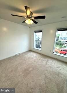 empty room featuring ceiling fan and carpet flooring