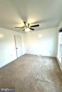 carpeted empty room featuring ceiling fan