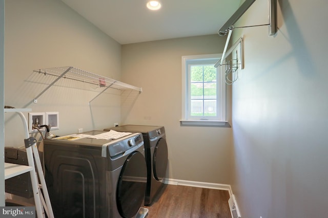 laundry room featuring dark wood-type flooring and washer and dryer