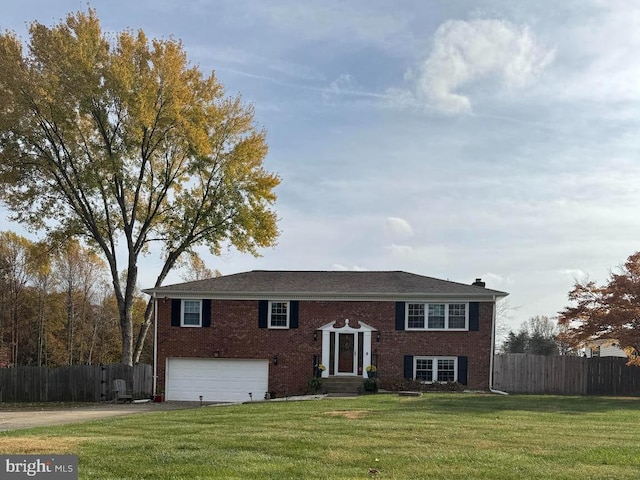 split foyer home featuring a garage and a front lawn