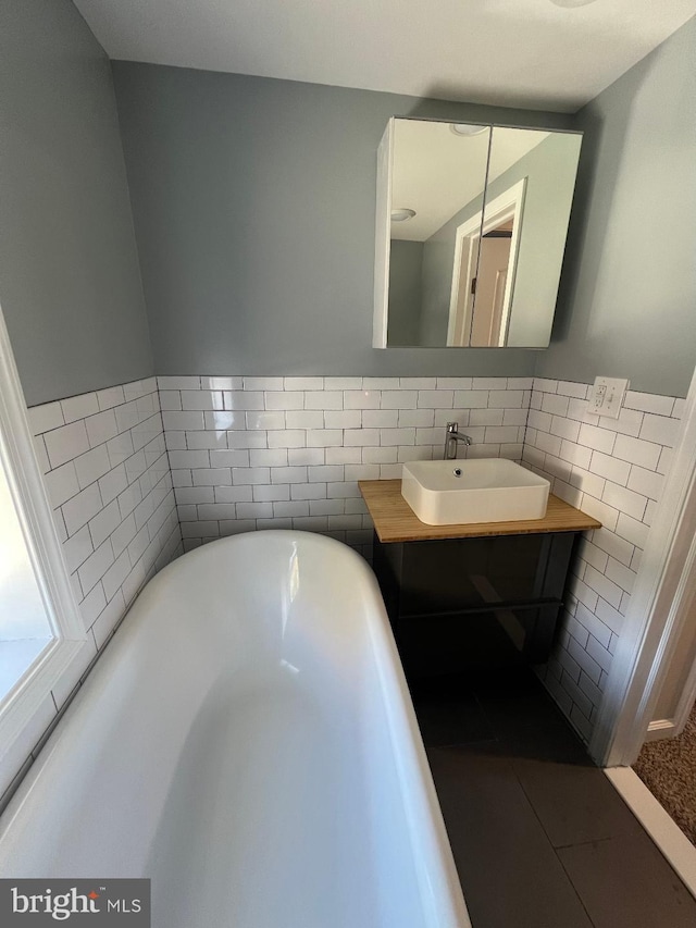 bathroom with vanity, a tub to relax in, and tile patterned flooring