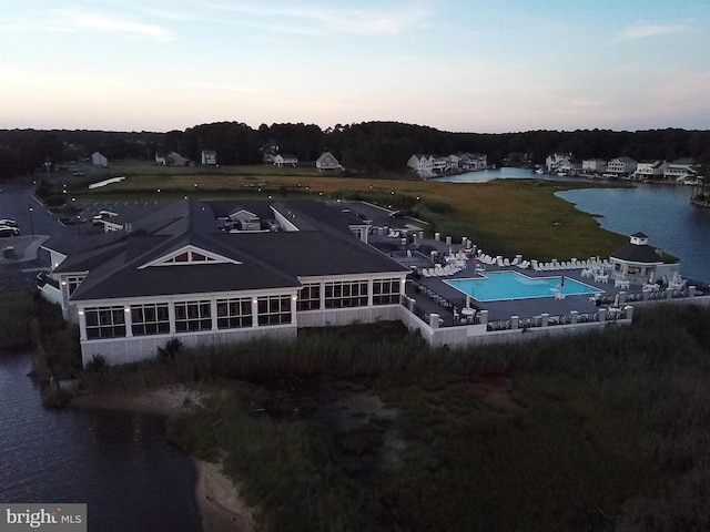 aerial view at dusk featuring a water view