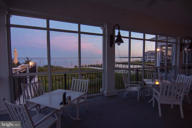 sunroom / solarium featuring a water view