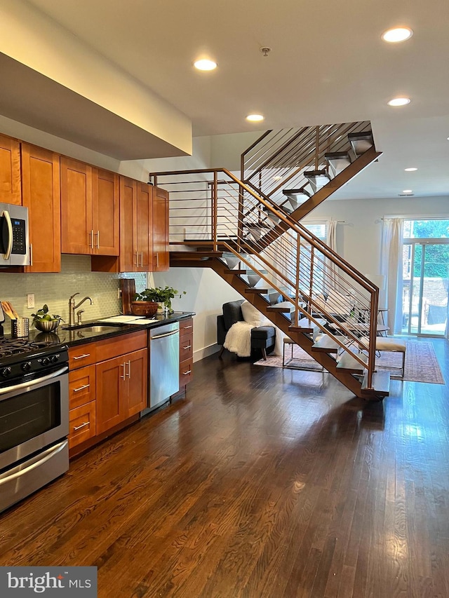 kitchen featuring backsplash, appliances with stainless steel finishes, dark hardwood / wood-style floors, and sink