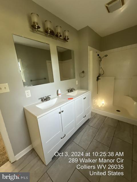 bathroom featuring a shower, vanity, and tile patterned floors