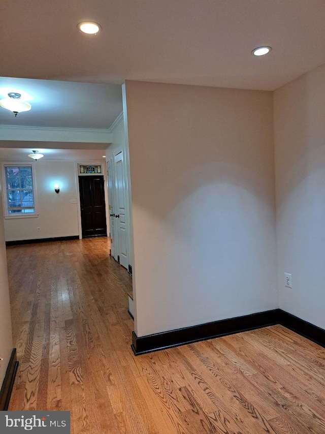 hallway featuring ornamental molding and hardwood / wood-style floors