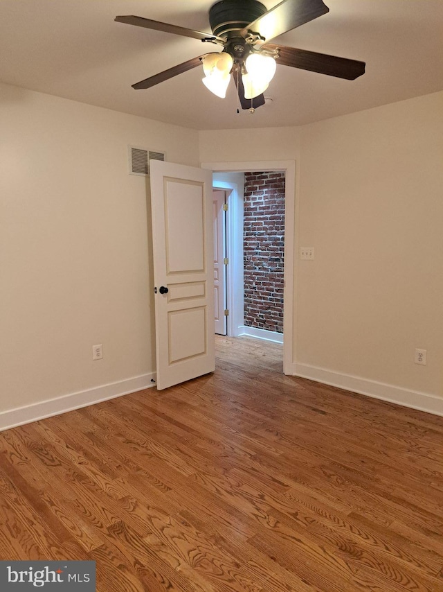 empty room with ceiling fan and hardwood / wood-style flooring