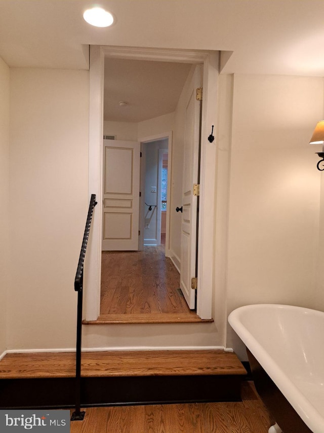 interior space featuring a tub to relax in and hardwood / wood-style floors