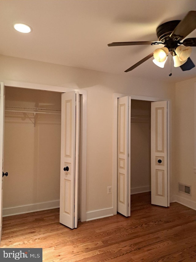 unfurnished bedroom with ceiling fan and hardwood / wood-style flooring