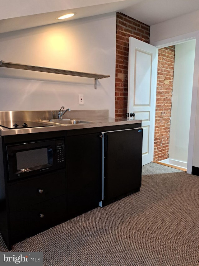 kitchen featuring black appliances, brick wall, light colored carpet, and sink