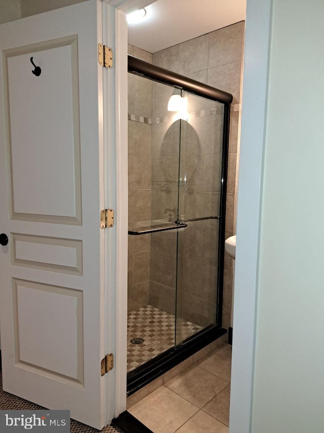 bathroom with tile patterned floors and a shower with shower door