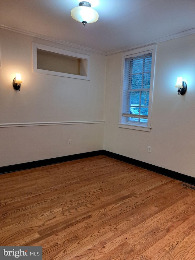 unfurnished room with crown molding and hardwood / wood-style floors