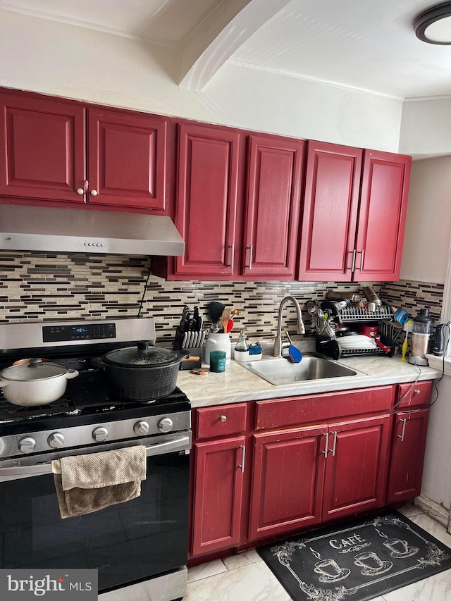 kitchen featuring stainless steel range oven, tasteful backsplash, and sink