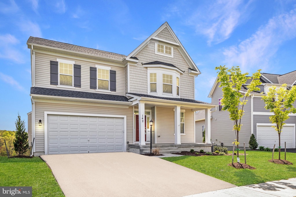 view of front of home featuring a garage, covered porch, and a front lawn