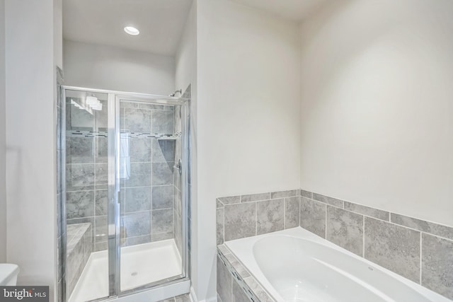 bathroom featuring shower with separate bathtub