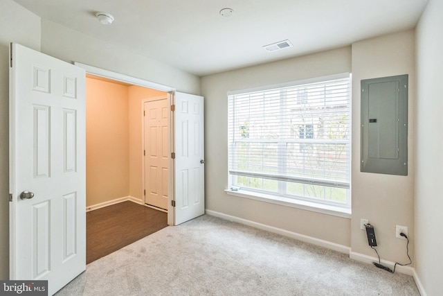 unfurnished bedroom with electric panel and carpet flooring