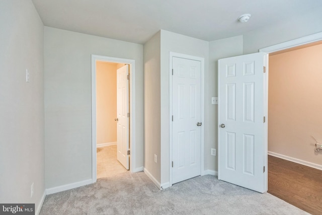 unfurnished bedroom featuring light carpet