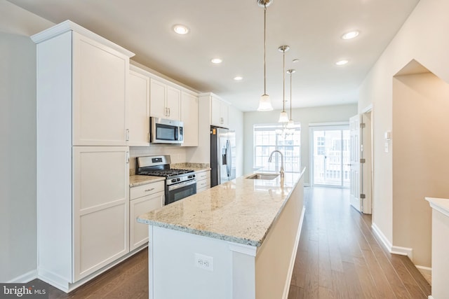 kitchen featuring a kitchen island with sink, appliances with stainless steel finishes, sink, and white cabinetry