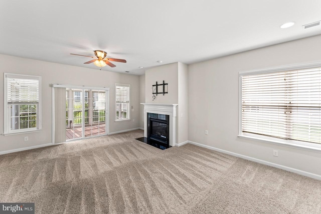 unfurnished living room with ceiling fan and carpet flooring