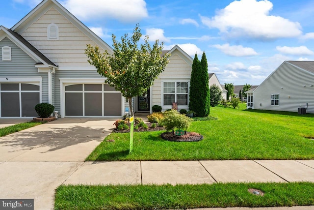 view of front of house with a garage, a front lawn, and central air condition unit