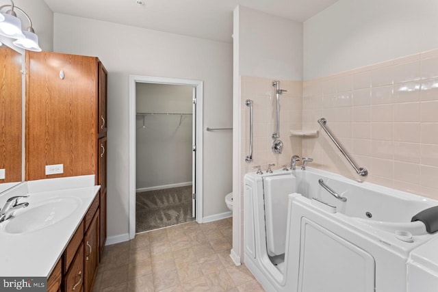 bathroom with a bath, vanity, and toilet