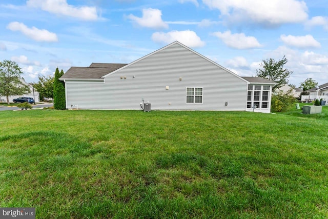 view of home's exterior with central AC unit and a yard