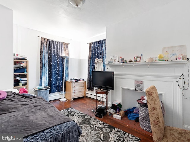 bedroom with a baseboard radiator and dark hardwood / wood-style flooring