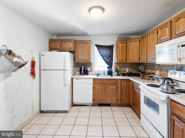 kitchen featuring white appliances, backsplash, sink, and light tile patterned floors