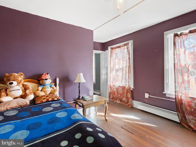 bedroom featuring baseboard heating and wood-type flooring