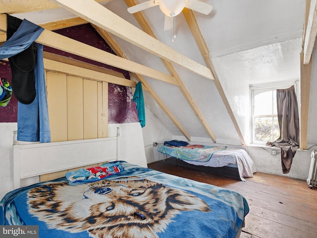 bedroom with ceiling fan, vaulted ceiling, and hardwood / wood-style floors